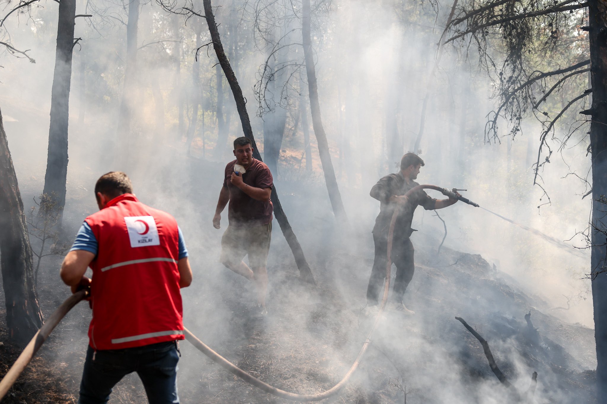 ''Bir yer yandığında tabii ki kimse oturup seyretmiyor; vatandaşlar da ellerinden ne geliyorsa, canla başla çabalıyorlar. Fakat 1980’li ve 90’lı yıllarda alıştığımız yangın rejiminde o ‘iyi’ yangınlara müdahale edilebiliyor iken, bugünkü ‘kötü’ yangınlarda bu gibi doğrudan müdahaleler çok riskli. Bundan imtina etmek gerekiyor.'' (Fotoğraf: “15-Turkish Red Crescent assistance to firefighters, July 2025” by Climate Centre, CC BY-NC-ND 4.0)